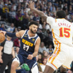 
              Denver Nuggets guard Jamal Murray, left, looks to pass the ball as Atlanta Hawks center Clint Capela defends in the second half of an NBA basketball game Saturday, Feb. 4, 2023, in Denver. (AP Photo/David Zalubowski)
            
