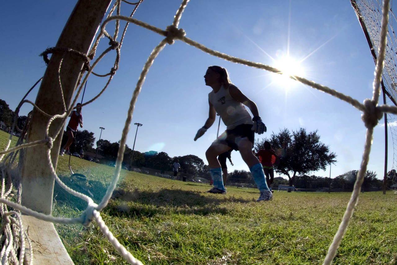 FILE - The goalkeeper guards the net as girls take part in the first day of tryouts for the Fort Wa...