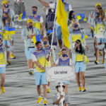 
              FILE - Olena Kostevych and Bogdan Nikishin, of Ukraine, carry their country's flag during the opening ceremony in the Olympic Stadium at the 2020 Summer Olympics, on July 23, 2021, in Tokyo, Japan. Ukraine has stepped up efforts to lobby international sports leaders against Russian participation in next year’s Paris Olympics as indications mount that the games could see the biggest boycott since the Cold War.  (AP Photo/David J. Phillip, File)
            