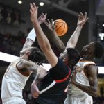 
              Texas forward Christian Bishop, left, guard Sir'Jabari Rice, right, and Texas Tech forward Fardaws Aimaq, center, fight for the ball during the first half of an NCAA college basketball game, Monday, Feb. 13, 2023, in Lubbock, Texas. (AP Photo/Justin Rex)
            