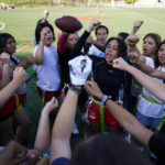 
              FILE - Elsa Morin, 17, center right, leads a chant as Redondo Union High School girls try out for a flag football team on Thursday, Sept. 1, 2022, in Redondo Beach, Calif. California officials are expected to vote Friday on the proposal to make flag football a girls' high school sport for the 2023-24 school year. (AP Photo/Ashley Landis, File)
            