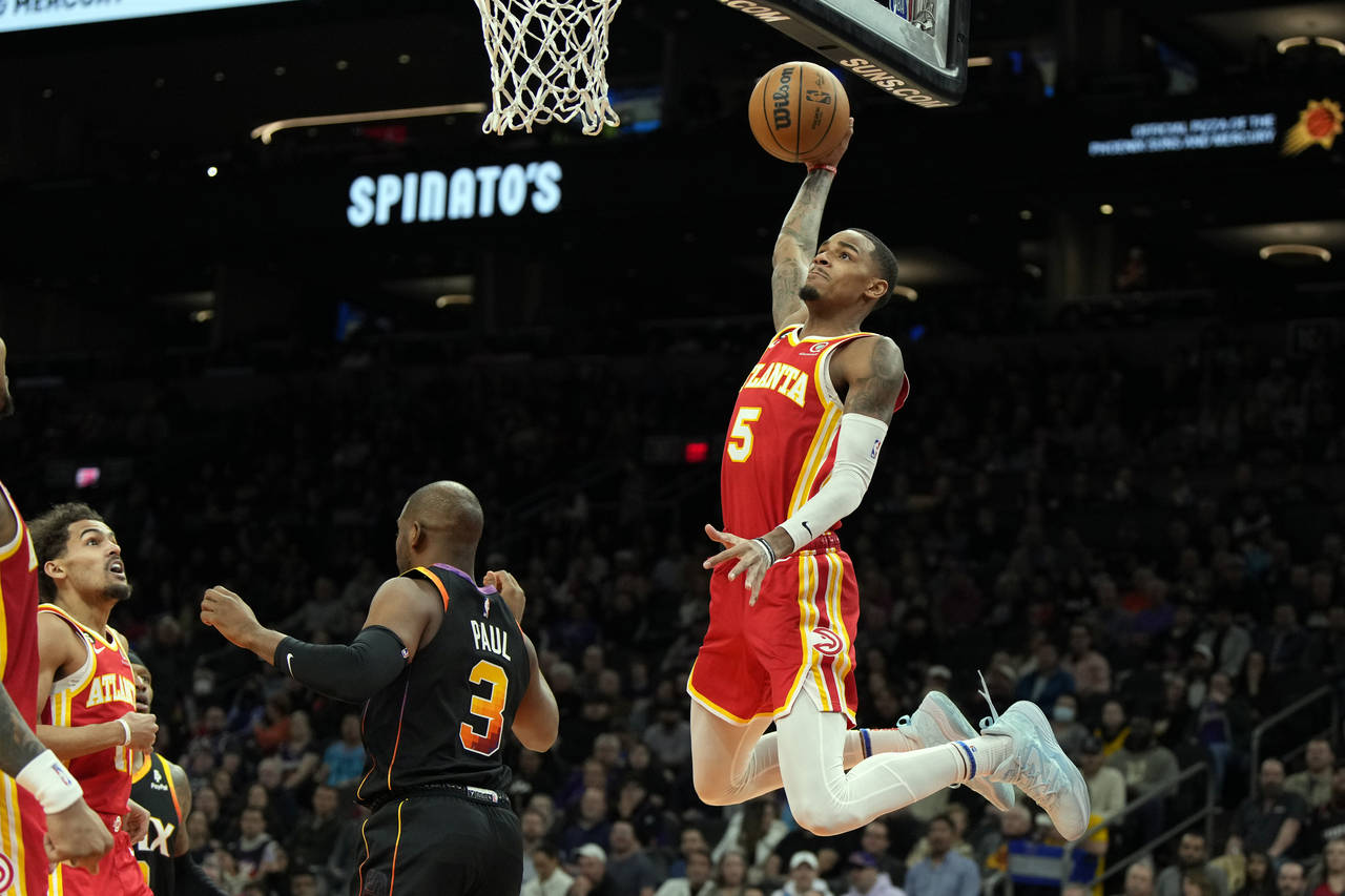 Atlanta Hawks guard Dejounte Murray (5) dunks over Phoenix Suns guard Chris Paul during the first h...