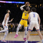 
              Los Angeles Lakers forward LeBron James, center, scores to pass Kareem Abdul-Jabbar to become the NBA's all-time leading scorer as Oklahoma City Thunder guard Josh Giddey, right, and forward Kenrich Williams defend during the second half of an NBA basketball game Tuesday, Feb. 7, 2023, in Los Angeles.(AP Photo/Ashley Landis)
            