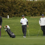 
              Beau Hossler, left, putts on the 13th green of the Pebble Beach Golf Links as Max McGreevy, center, and Lukas Nelson, second from right, look on during the second round of the AT&T Pebble Beach Pro-Am golf tournament in Pebble Beach, Calif., Friday, Feb. 3, 2023. A caddie for one of the amateurs in the group collapsed on the 11th fairway and was rushed to the hospital. (AP Photo/Eric Risberg)
            