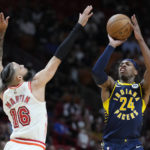 
              Indiana Pacers guard Buddy Hield (24) takes a shot against Miami Heat forward Caleb Martin (16) during the first half of an NBA basketball game, Wednesday, Feb. 8, 2023, in Miami. (AP Photo/Wilfredo Lee)
            