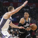 
              Los Angeles Clippers guard Russell Westbrook, right, drives by Sacramento Kings forward Domantas Sabonis during the first half of an NBA basketball game Friday, Feb. 24, 2023, in Los Angeles. (AP Photo/Mark J. Terrill)
            