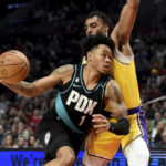 
              Portland Trail Blazers guard Anfernee Simons, left, drives to the basket against Los Angeles Lakers forward Troy Brown Jr., right, during the first half of an NBA basketball game in Portland, Ore., Monday, Feb. 13, 2023. (AP Photo/Steve Dykes)
            