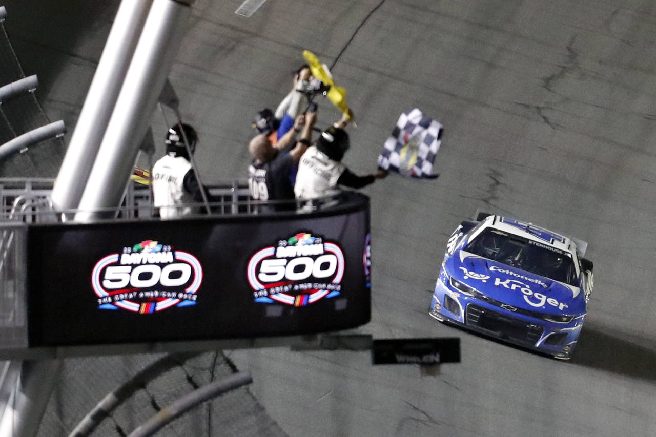 Ricky Stenhouse Jr. takes the checkered flag to win the NASCAR Daytona 500 auto race at Daytona Int...
