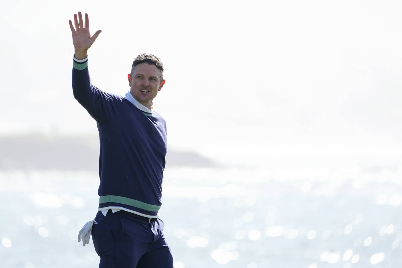 Justin Rose, of England, reacts after making a par putt on the 18th green of the Pebble Beach Golf ...