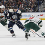 
              Columbus Blue Jackets' Kent Johnson, center, carries the puck across the blue line between Minnesota Wild's Ryan Hartman, left, and Jared Spurgeon during the second period of an NHL hockey game Thursday, Feb. 23, 2023, in Columbus, Ohio. (AP Photo/Jay LaPrete)
            