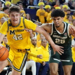 
              Michigan forward Will Tschetter (42) drives as Michigan State forward Malik Hall (25) defends during the second half of an NCAA college basketball game, Saturday, Feb. 18, 2023, in Ann Arbor, Mich. (AP Photo/Carlos Osorio)
            