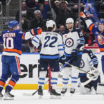 
              Winnipeg Jets' Kevin Stenlund (28) watches New York Islanders' Bo Horvat and Simon Holmstrom (10) celebrate after Holmstrom scored a goal during the third period of an NHL hockey game Wednesday, Feb. 22, 2023, in Elmont, N.Y. The Islanders won 2-1. (AP Photo/Frank Franklin II)
            
