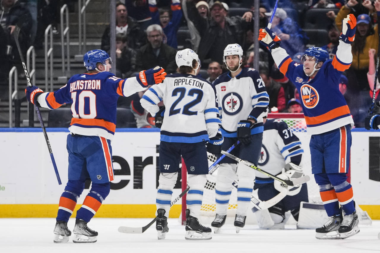 Winnipeg Jets' Kevin Stenlund (28) watches New York Islanders' Bo Horvat and Simon Holmstrom (10) c...