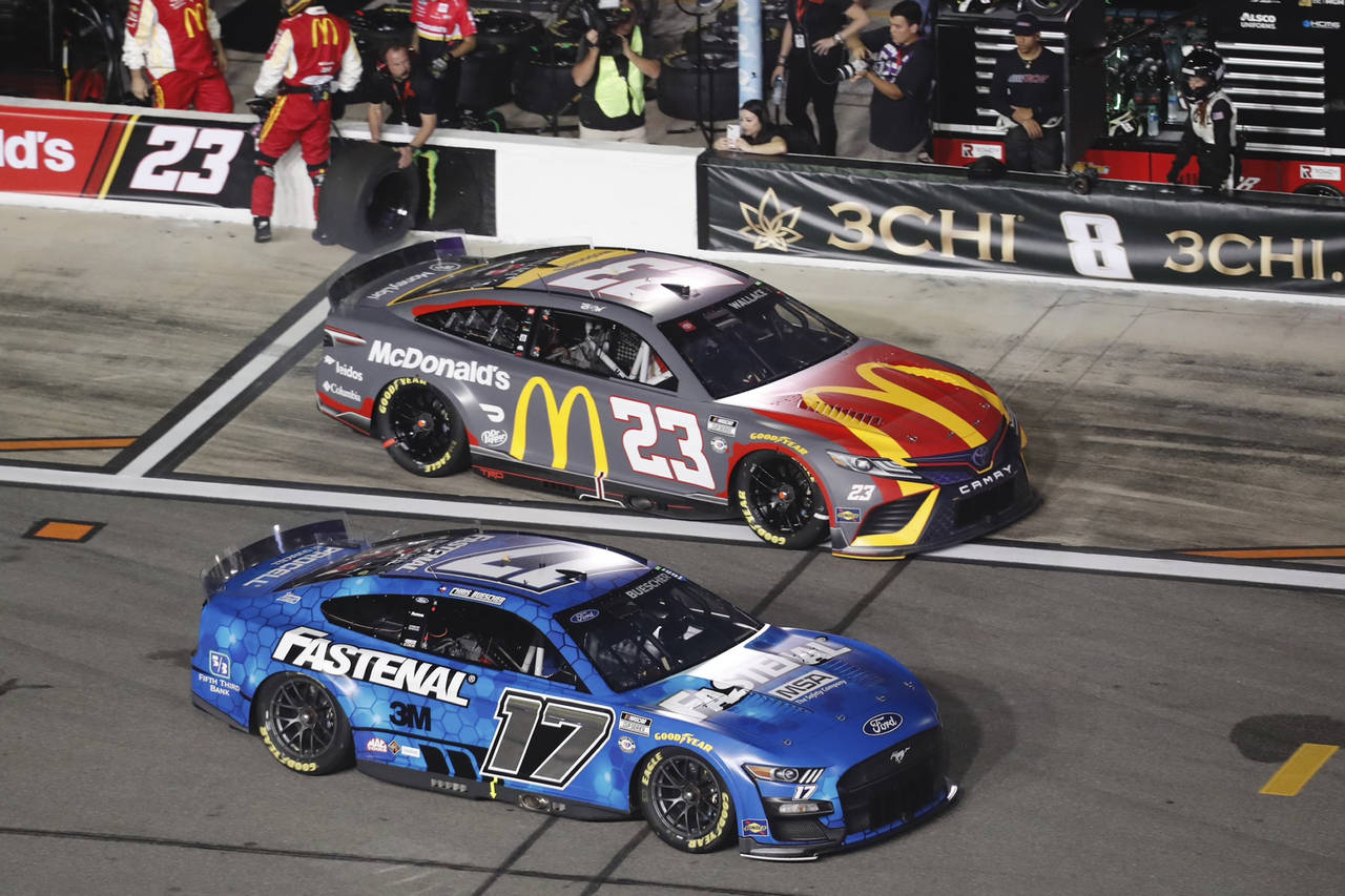Chris Buescher (17) jumps ahead of Bubba Wallace (23) after a pit stop during the first of two qual...