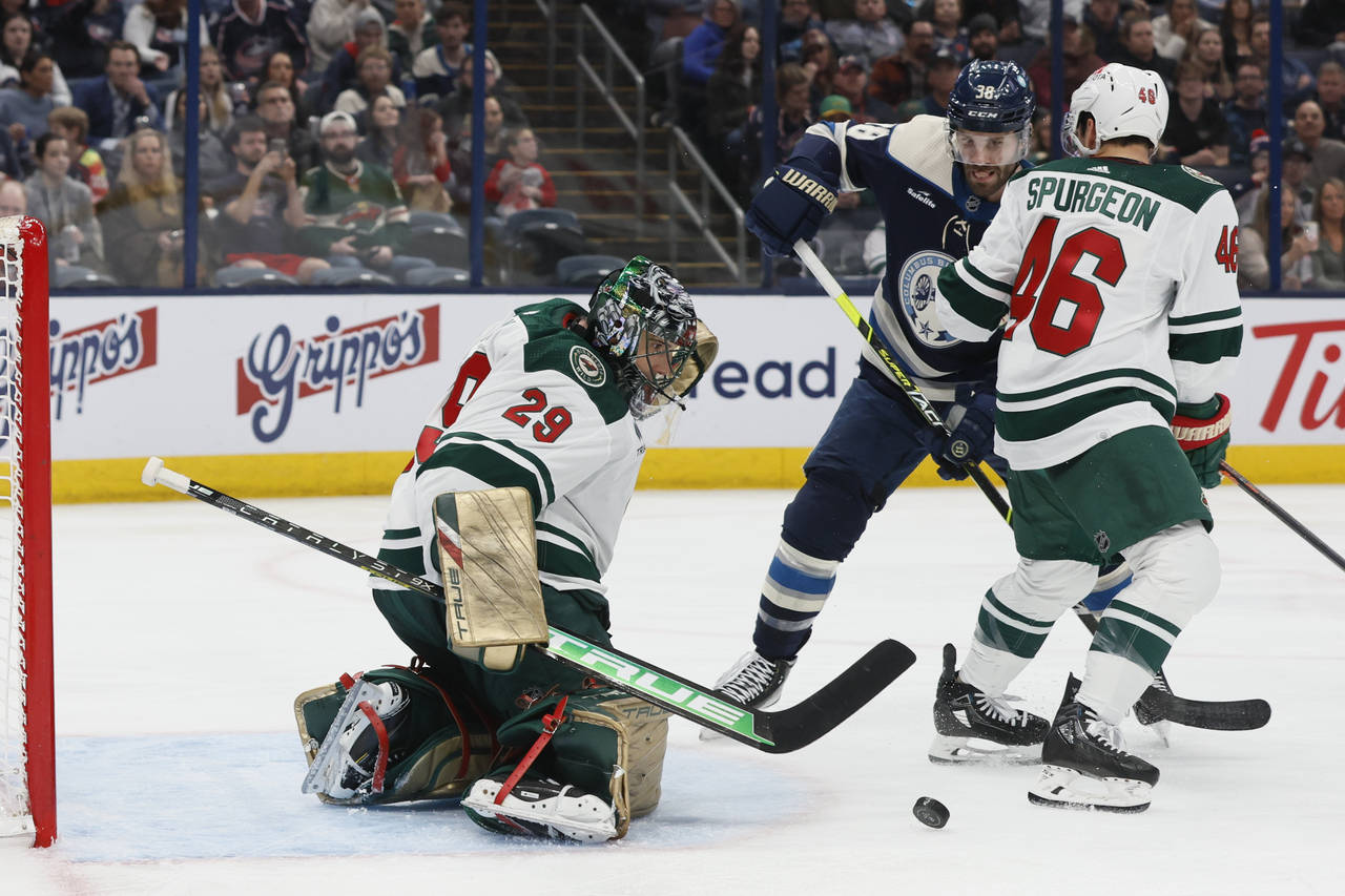 Minnesota Wild's Marc-Andre Fleury, left, makes a save as Jared Spurgeon, right, and Columbus Blue ...
