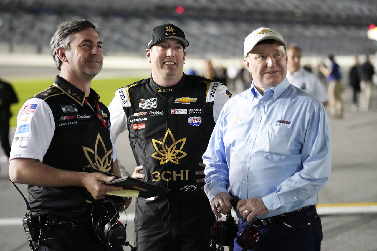 Kyle Busch, center, stands on pit road with his crew chief Randall Burnett, left, and car owner Ric...