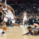 
              Sacramento Kings guard De'Aaron Fox, center, loses his shoe as he takes a loose ball away from Los Angeles Clippers forward Paul George, right, during the second half of an NBA basketball game Friday, Feb. 24, 2023, in Los Angeles. (AP Photo/Mark J. Terrill)
            