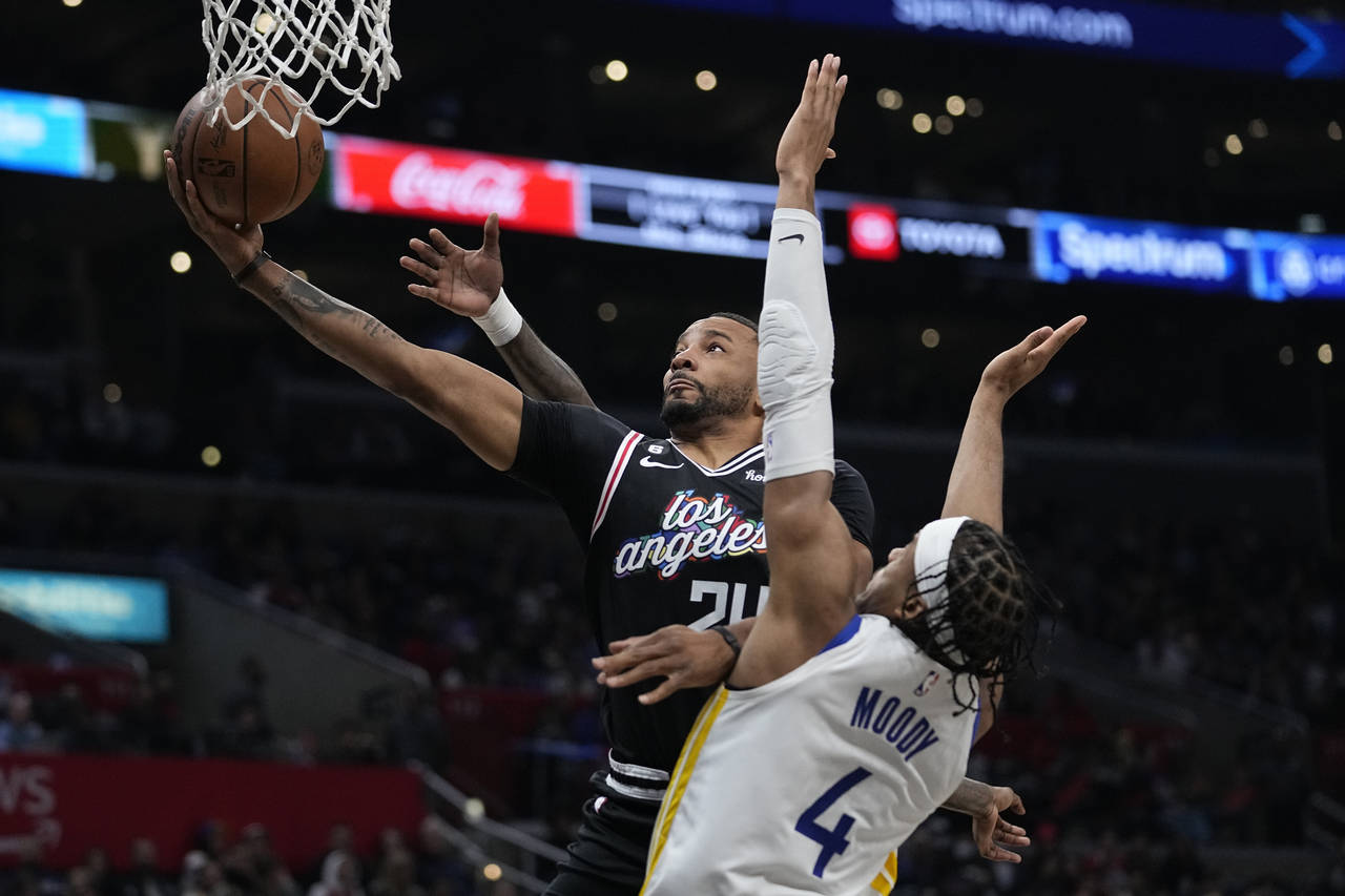 Los Angeles Clippers forward Norman Powell, left, shoots as Golden State Warriors guard Moses Moody...