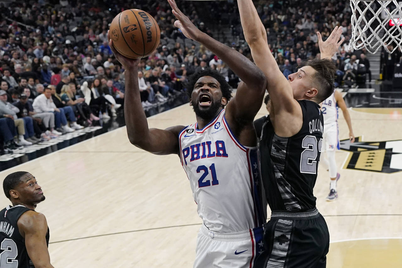 Philadelphia 76ers center Joel Embiid (21) is fouled as he drives to the basket against San Antonio...