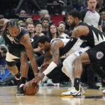 
              Dallas Mavericks guard Kyrie Irving, center, scrambles for a ball along with Los Angeles Clippers forward Kawhi Leonard, left, and forward Paul George during the second half of an NBA basketball game Wednesday, Feb. 8, 2023, in Los Angeles. (AP Photo/Mark J. Terrill)
            