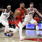 
              Portland Trail Blazers guard Damian Lillard, center, drives to the basket against Washington Wizards guard Delon Wright, left, and forward Deni Avdija, right, during the first half of an NBA basketball game in Portland, Ore., Tuesday, Feb. 14, 2023. (AP Photo/Steve Dykes)
            