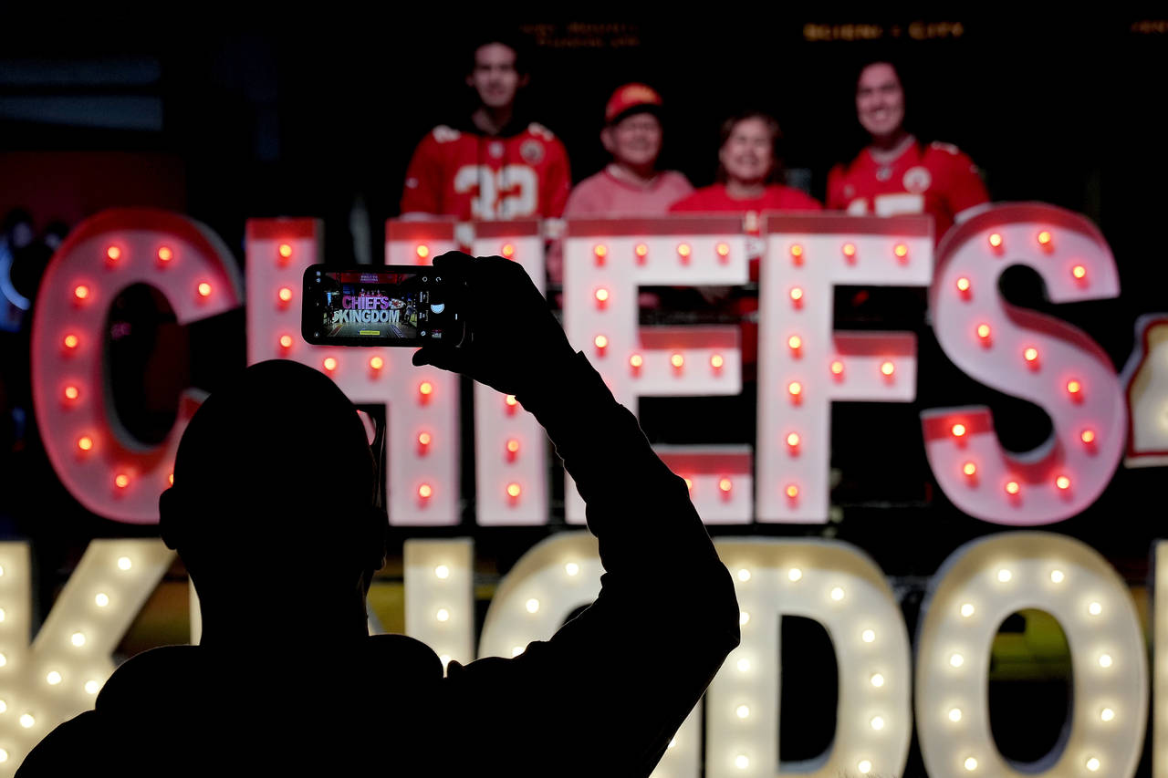 People have their photo taken with signage for the Kansas City Chiefs NFL football team while visit...