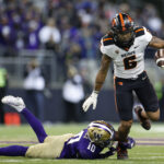 SEATTLE, WASHINGTON - NOVEMBER 04: Damien Martinez #6 of the Oregon State Beavers carries the ball against Davon Banks #10 of the Washington Huskies during the first quarter of the game at Husky Stadium on November 04, 2022 in Seattle, Washington. (Photo by Steph Chambers/Getty Images)
