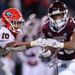 STARKVILLE, MISSISSIPPI - NOVEMBER 12: Dillon Johnson #23 of the Mississippi State Bulldogs runs with the ball as Jamon Dumas-Johnson #10 of the Georgia Bulldogs defends during the second half of the game at Davis Wade Stadium on November 12, 2022 in Starkville, Mississippi. (Photo by Jonathan Bachman/Getty Images)