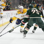 
              Nashville Predators left wing Tanner Jeannot, left, reaches for the puck next to Minnesota Wild defenseman Jonas Brodin (25) during the second period of an NHL hockey game Sunday, Feb. 19, 2023, in St. Paul, Minn. (AP Photo/Abbie Parr)
            
