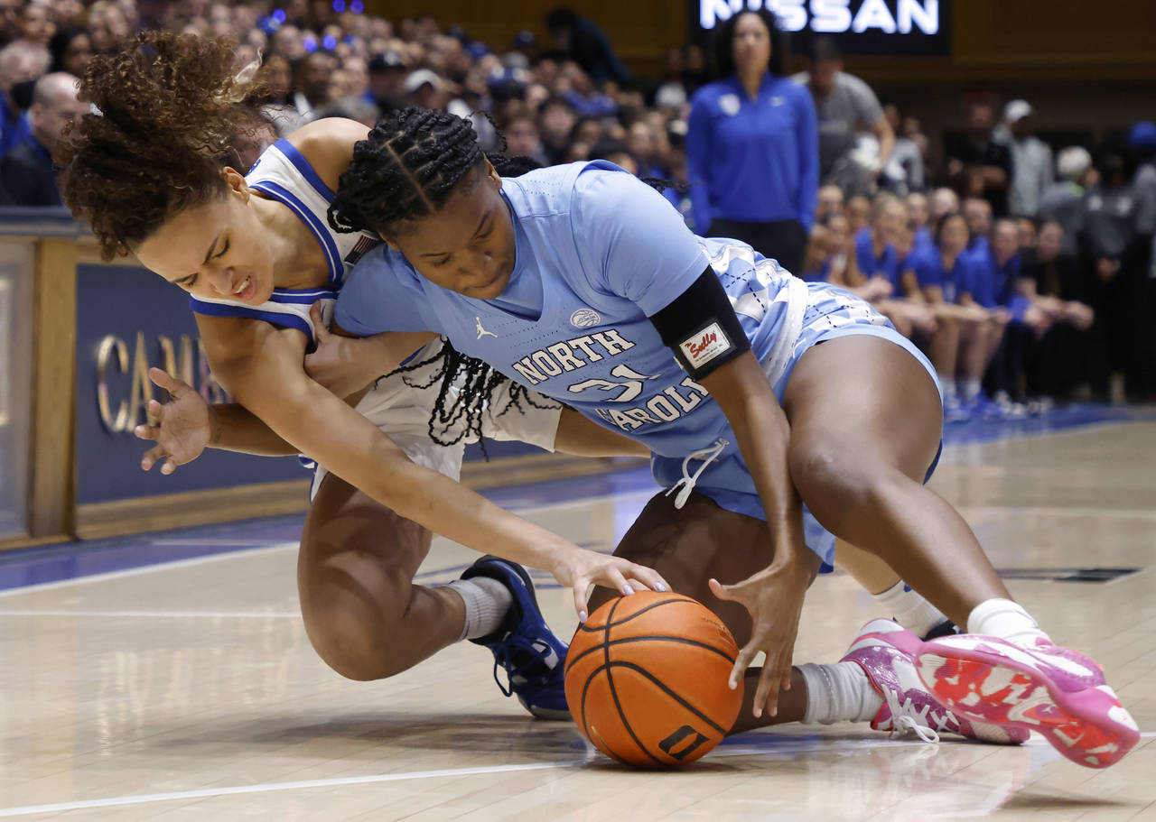 Duke's Celeste Taylor, left, and North Carolina's Anya Poole dive for the ball during the first hal...
