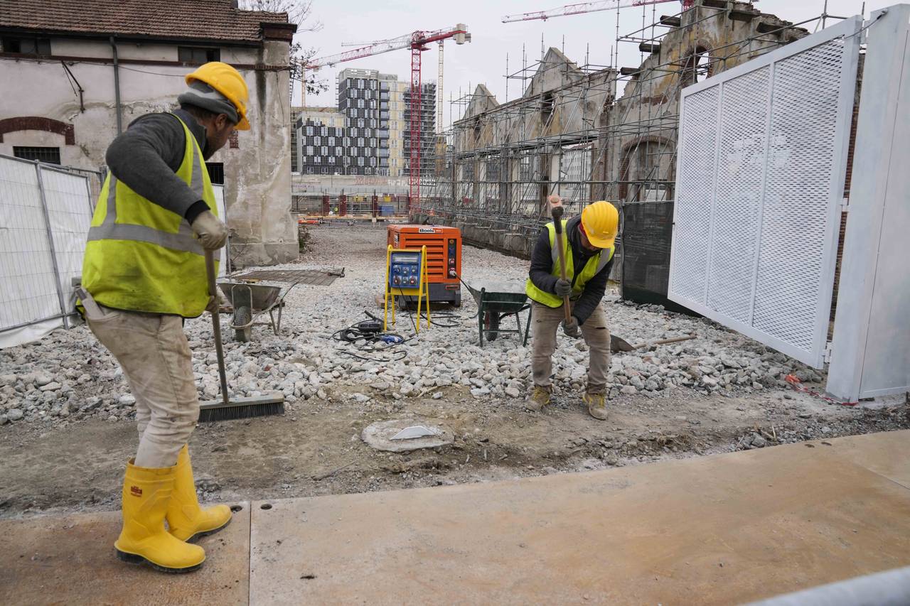 Workers operate inside the construction site of the Olympic Village at the Porta Romana former rail...