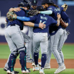TORONTO, ON - APRIL 30: Cal Raleigh #29, Kolten Wong #16, and J.P. Crawford #3 of the Seattle Mariners celebrate alongside their team after their victory over the Toronto Blue Jays at the end of the tenth inning of their MLB game at Rogers Centre on April 30, 2023 in Toronto, Canada. (Photo by Cole Burston/Getty Images)