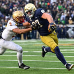 SOUTH BEND, INDIANA - NOVEMBER 19: Michael Mayer #87 of the Notre Dame Fighting Irish runs for a first down in the first half against Jaiden Woodbey #9 of the Boston College Eagles at Notre Dame Stadium on November 19, 2022 in South Bend, Indiana. (Photo by Quinn Harris/Getty Images)