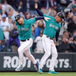 SEATTLE, WASHINGTON - APRIL 14: Jarred Kelenic #10 of the Seattle Mariners celebrates his two run home run with Manny Acta #14 during the second inning against the Colorado Rockies at T-Mobile Park on April 14, 2023 in Seattle, Washington. (Photo by Steph Chambers/Getty Images)