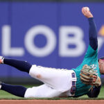 SEATTLE, WASHINGTON - MAY 06: Kolten Wong #16 of the Seattle Mariners attempts to throw to first base during the fifth inning against the Houston Astros at T-Mobile Park on May 06, 2023 in Seattle, Washington. (Photo by Steph Chambers/Getty Images)