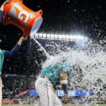 SEATTLE, WASHINGTON - MAY 06: Tom Murphy #2 douses Jose Caballero #76 of the Seattle Mariners with water after beating the Houston Astros 7-5 at T-Mobile Park on May 06, 2023 in Seattle, Washington. (Photo by Steph Chambers/Getty Images)