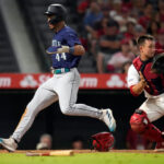 ANAHEIM, CALIFORNIA - AUGUST 4: Julio Rodriguez #44 of the Seattle Mariners scores the go-ahead run against catcher Matt Thaiss #21 of the Los Angeles Angels during the eighth inning at Angel Stadium of Anaheim on August 4, 2023 in Anaheim, California. (Photo by Kevork Djansezian/Getty Images)