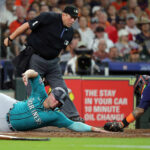 HOUSTON, TEXAS - AUGUST 19: Ty France #23 of the Seattle Mariners scores in the third inning on a double by Teoscar Hernandez as Martin Maldonado #15 of the Houston Astros can't handle the throw at Minute Maid Park on August 19, 2023 in Houston, Texas. (Photo by Bob Levey/Getty Images)
