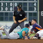 HOUSTON, TEXAS - AUGUST 19: Jose Altuve #27 of the Houston Astros is tagged out by Dylan Moore #25 of the Seattle Mariners attempting to stretch a single in the fifth inning at Minute Maid Park on August 19, 2023 in Houston, Texas. (Photo by Bob Levey/Getty Images)