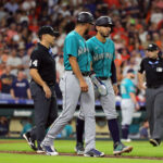HOUSTON, TEXAS - AUGUST 19: Jose Caballero #76 of the Seattle Mariners walks to first base with first base coach Kristopher Negron after being hit by a pitch in the fifth inning against the Houston Astros at Minute Maid Park on August 19, 2023 in Houston, Texas. (Photo by Bob Levey/Getty Images)