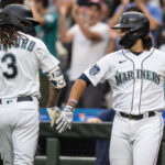 SEATTLE, WA - AUGUST 28: J.P. Crawford #3 of the Seattle Mariners is congratulated by Eugenio Suarez #28 of the Seattle Mariners after hitting a solo home run off of Oakland Athletics Kyle Muller #39 during the first inning of a game at T-Mobile Park on August 28, 2023 in Seattle, Washington. (Photo by Stephen Brashear/Getty Images)