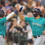 CHICAGO, ILLINOIS - AUGUST 21: Josh Rojas #4 and Eugenio Suarez #28 of the Seattle Mariners celebrate after scoring a run on a two-run single by Teoscar Hernandez #35 (not pictured) against the Chicago White Sox during the sixth inning at Guaranteed Rate Field on August 21, 2023 in Chicago, Illinois. (Photo by Michael Reaves/Getty Images)