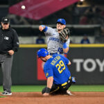 SEATTLE, WASHINGTON - AUGUST 25: Michael Massey #19 of the Kansas City Royals throws to first base to complete the double play against a sliding Cal Raleigh #29 of the Seattle Mariners during the sixth inning at T-Mobile Park on August 25, 2023 in Seattle, Washington. (Photo by Alika Jenner/Getty Images)