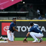 SEATTLE, WASHINGTON - AUGUST 30: J.P. Crawford #3 of the Seattle Mariners flips the ball to Josh Rojas #4 after making a play during the first inning against the Oakland Athletics at T-Mobile Park on August 30, 2023 in Seattle, Washington. (Photo by Alika Jenner/Getty Images)