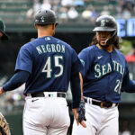 SEATTLE, WASHINGTON - AUGUST 30: Eugenio Suarez #28 of the Seattle Mariners shakes hands with first base coach Kristopher Negrón #45after hitting a single during the first inning against the Oakland Athletics at T-Mobile Park on August 30, 2023 in Seattle, Washington. (Photo by Alika Jenner/Getty Images)