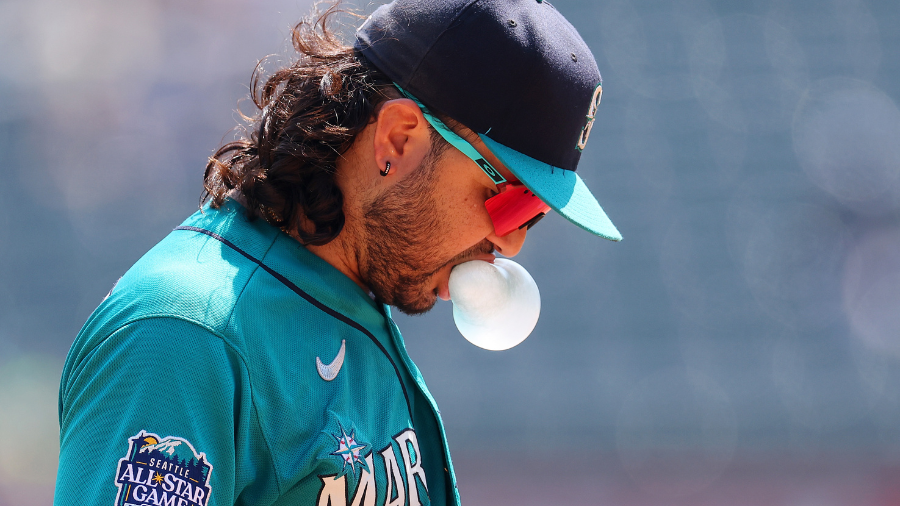 Seattle Mariners' Eugenio Suarez blows a bubble while on the bench