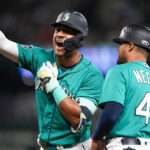 Seattle Mariners' Julio Rodriguez celebrates after hitting an RBI single against the Los Angeles Angels during the fourth inning of a baseball game, next to first base coach Kristopher Negrón (45) on Tuesday, Sept. 12, 2023, in Seattle. (AP Photo/Lindsey Wasson)Credit: ASSOCIATED PRESS