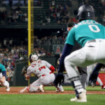 SEATTLE, WASHINGTON - SEPTEMBER 12: Ty France #23 of the Seattle Mariners dives for home plate as Sam Haggerty #0 gestures but is later tagged out by Logan O'Hoppe #14 of the Los Angeles Angels during the first inning at T-Mobile Park on September 12, 2023 in Seattle, Washington. (Photo by Steph Chambers/Getty Images)