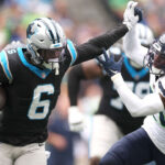 SEATTLE, WASHINGTON - SEPTEMBER 24: Miles Sanders #6 of the Carolina Panthers stiff arms Devon Witherspoon #21 of the Seattle Seahawks during the second quarter at Lumen Field on September 24, 2023 in Seattle, Washington. (Photo by Steph Chambers/Getty Images)