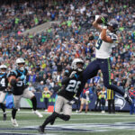 SEATTLE, WASHINGTON - SEPTEMBER 24: Jake Bobo #19 of the Seattle Seahawks catches a touchdown over Donte Jackson #26 of the Carolina Panthers during the fourth quarter at Lumen Field on September 24, 2023 in Seattle, Washington. (Photo by Steph Chambers/Getty Images)